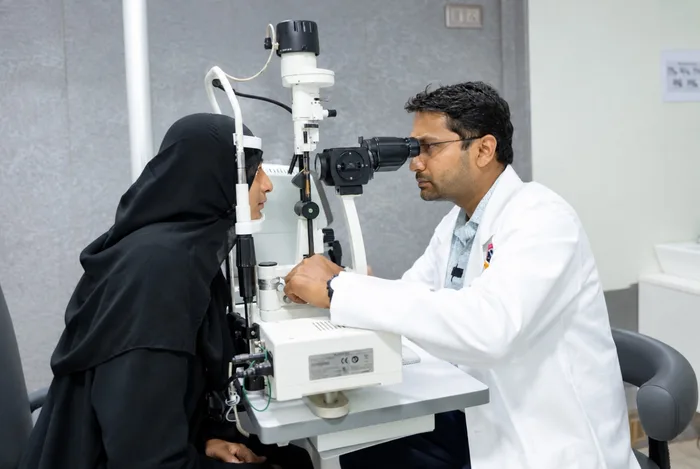 Ophthalmologist conducting slit-lamp examination on patient in consultation room