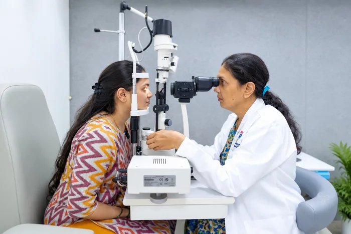 Female ophthalmologist examining patient with slit-lamp microscope