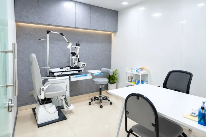 Private doctor consultation chamber with motorized patient examination chair and desk